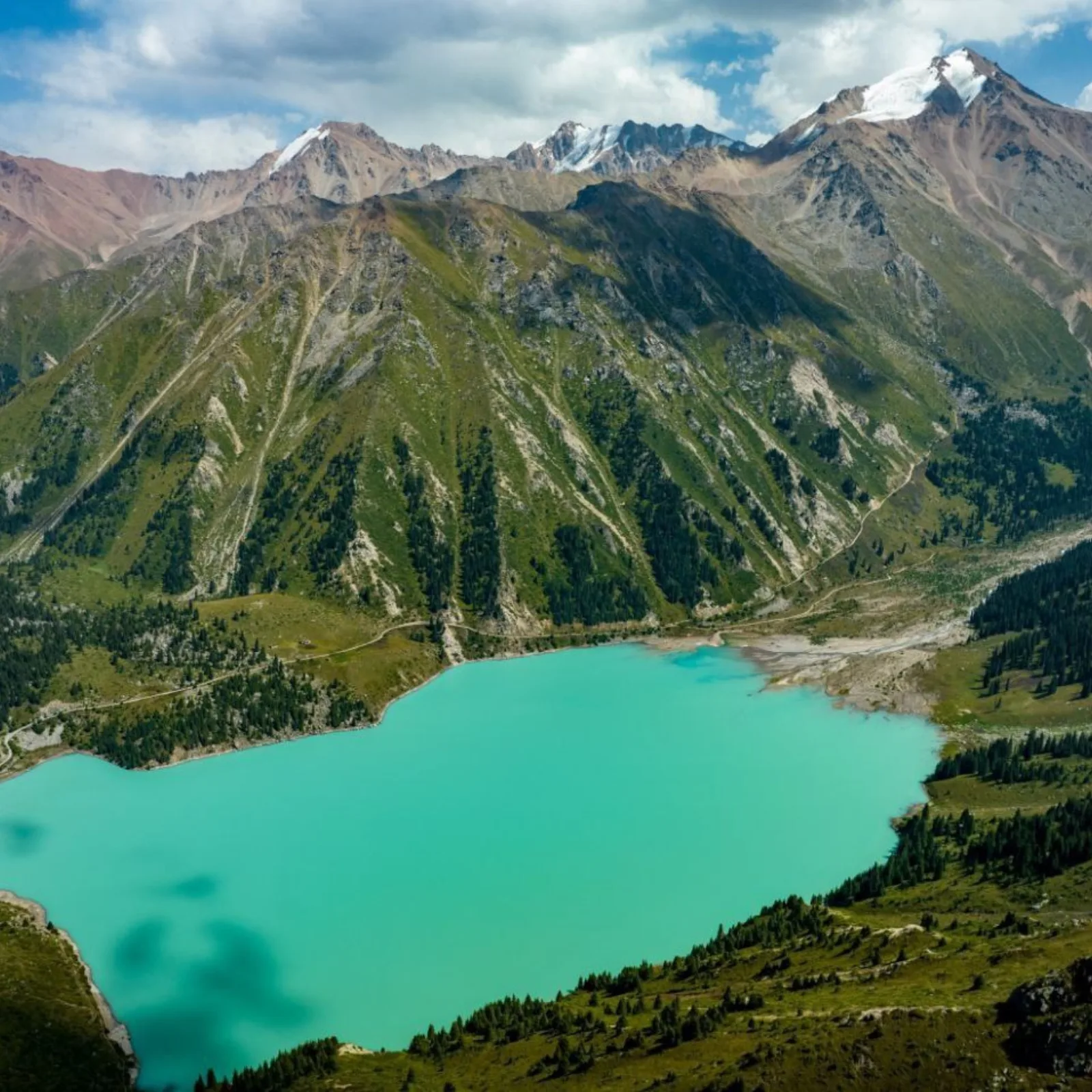 Aerial view of Big Almaty Lake's turquoise water and forested shoreline