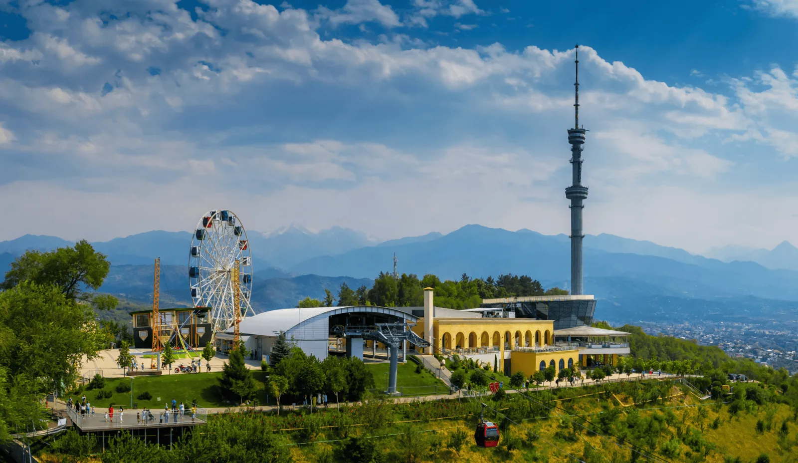 Kok Tobe's ferris wheel and cable car with the city and mountains behind